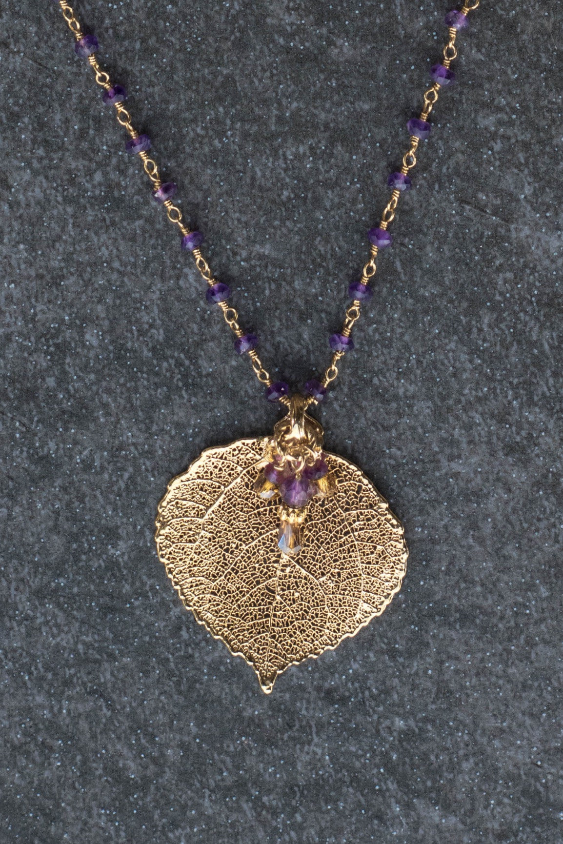 Gems in gold chain: Amethyst gems accent this classic princess style necklace with a gold leaf and Amethyst dangle