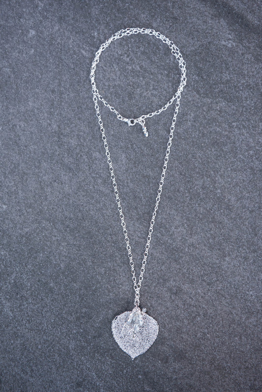 Classic silver chain creates this striking long necklace with a Silver leaf and crystal dangles