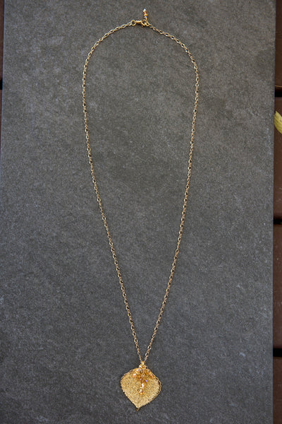 Classic Gold chain creates this striking long necklace with a Gold leaf and crystal dangles