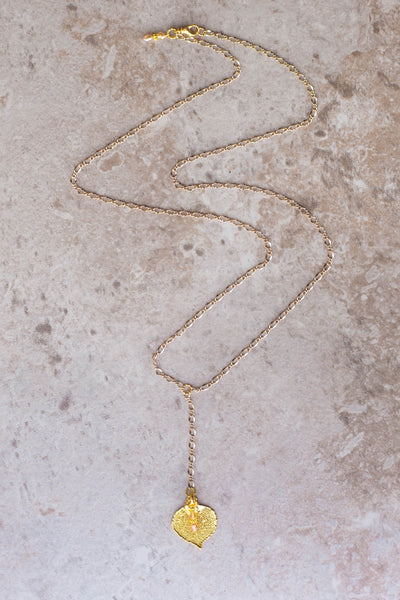 Classic Gold chain creates this dramatic Y style long necklace with a small Gold leaf