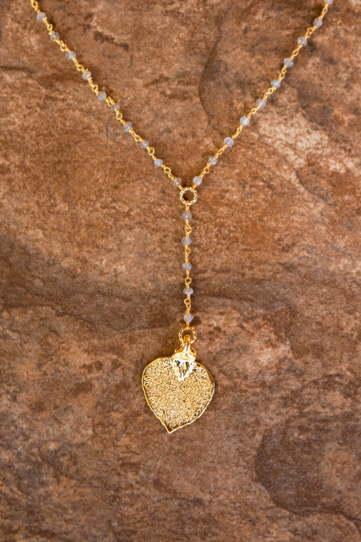 Gems in gold chain: labradorite gems accent the dramatic Y style necklace with a small gold leaf