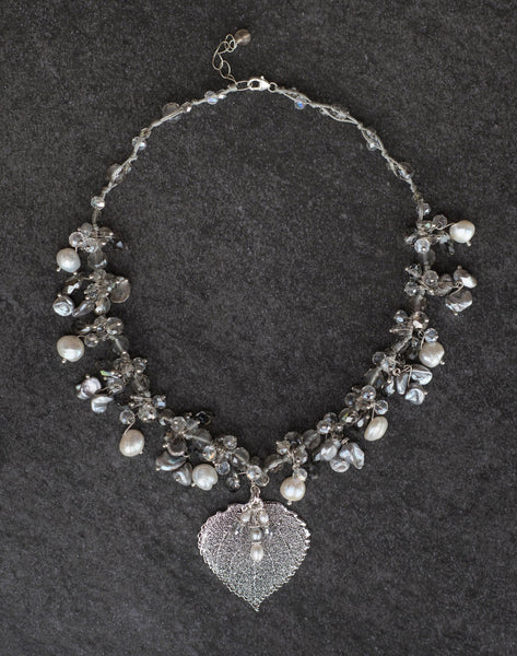 Elegant silver and white pearls are woven into this exquisite necklace with crystals and a silver Aspen leaf.  A pearl & Chrystal dangle completes the piece