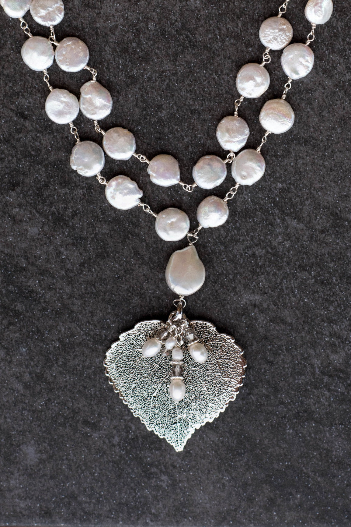 Wire twisted silver wire combine 2 strands of white freshwater coin pearls with a silver Aspen leaf & pearl dangle.