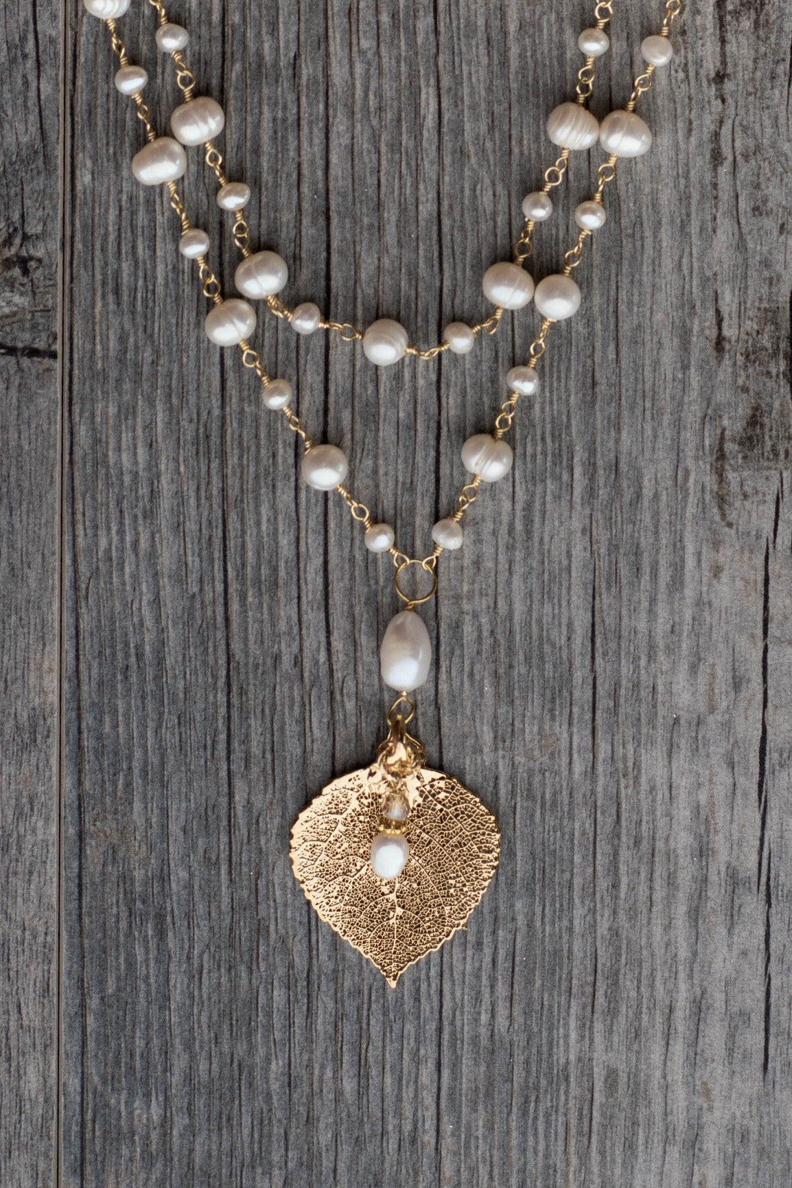 Wire twisted gold wire combine 2 strands of white freshwater coin pearls finished with a Gold Aspen leaf & pearl dangle.