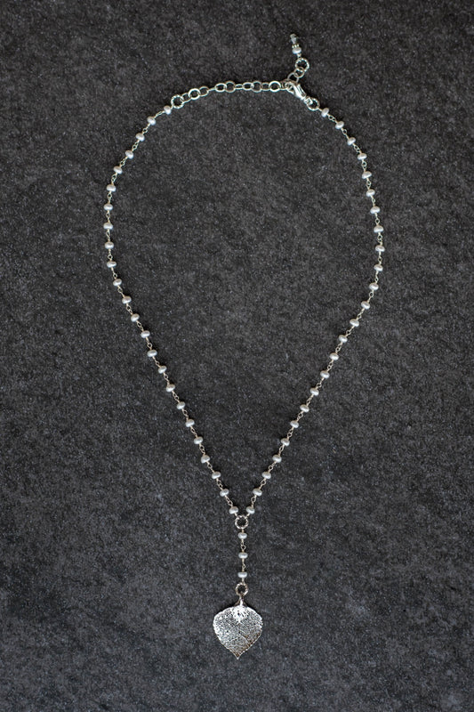 Pearls in silver chain: Fresh water pearls accent the dramatic Y style necklace with a small silver leaf