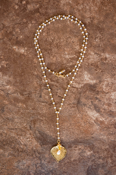 Pearls in gold chain: White freshwater pearls accent this dramatic Y shaped necklace with a small gold leaf and pearl dangle