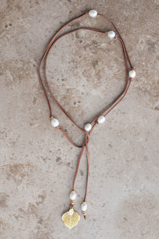 Lariat: Eight pearls highlight this versatile necklace, White freshwater pearls, gold Aspen leaf, brown  deerskin leather.