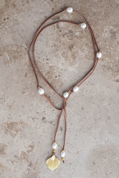 Lariat: Eight pearls highlight this versatile necklace, White freshwater pearls, gold Aspen leaf, brown  deerskin leather.