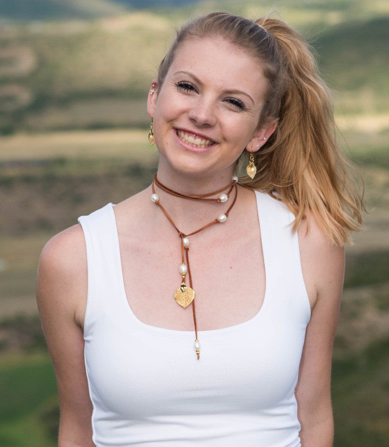 Lariat: Eight pearls highlight this versatile necklace, White freshwater pearls, gold Aspen leaf, brown  deerskin leather.