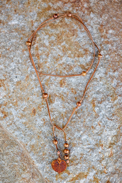 Lariat: twelve pearls highlight this versatile necklace, Bronze freshwater pearls, copper Aspen leaf, brown deerskin leather.