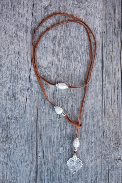 Three White pearls, silver leaf, brown leather creates this original and trendy necklace