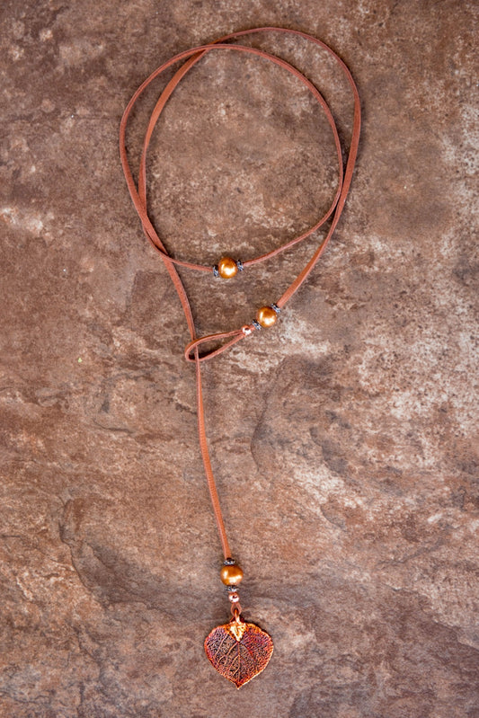 Three bronze pearls copper leaf, brown leather creates this original and trendy necklace