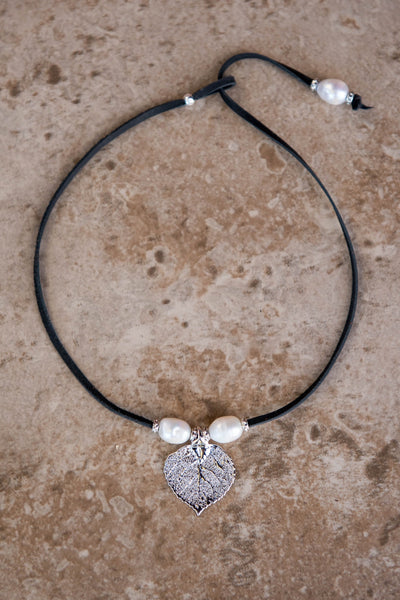 Three pearls choker: White pearls with a silver leaf, come together with black leather for this trendy versatile necklace