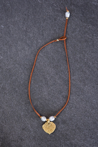 Three pearls choker: White pearls with a gold leaf, come together with brown leather for this trendy versatile necklace
