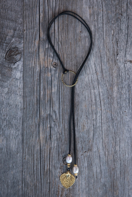 Two White pearls, gold leaf, black leather and pounded gold ring