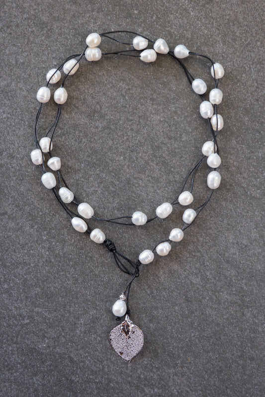 Lariat: Multi pearls accent this impressive necklace, White freshwater pearls, silver Aspen leaf, black cord leather.