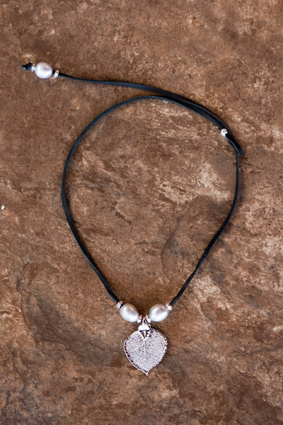 Three pearls choker: silver pearls with a silver leaf, come together with black leather for this trendy versatile necklace