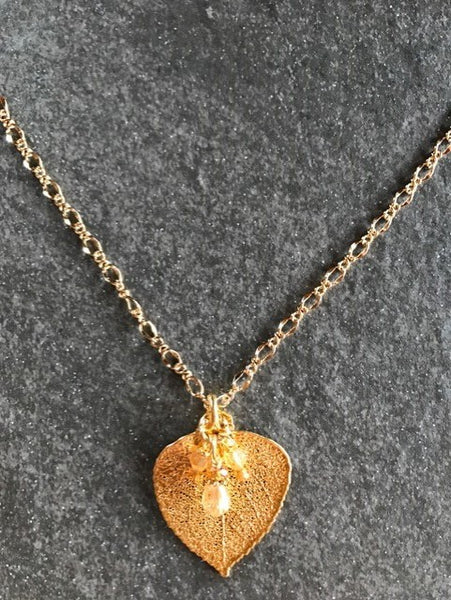 Classic gold chain creates this delicate style necklace with a small Gold leaf & crystal dangle